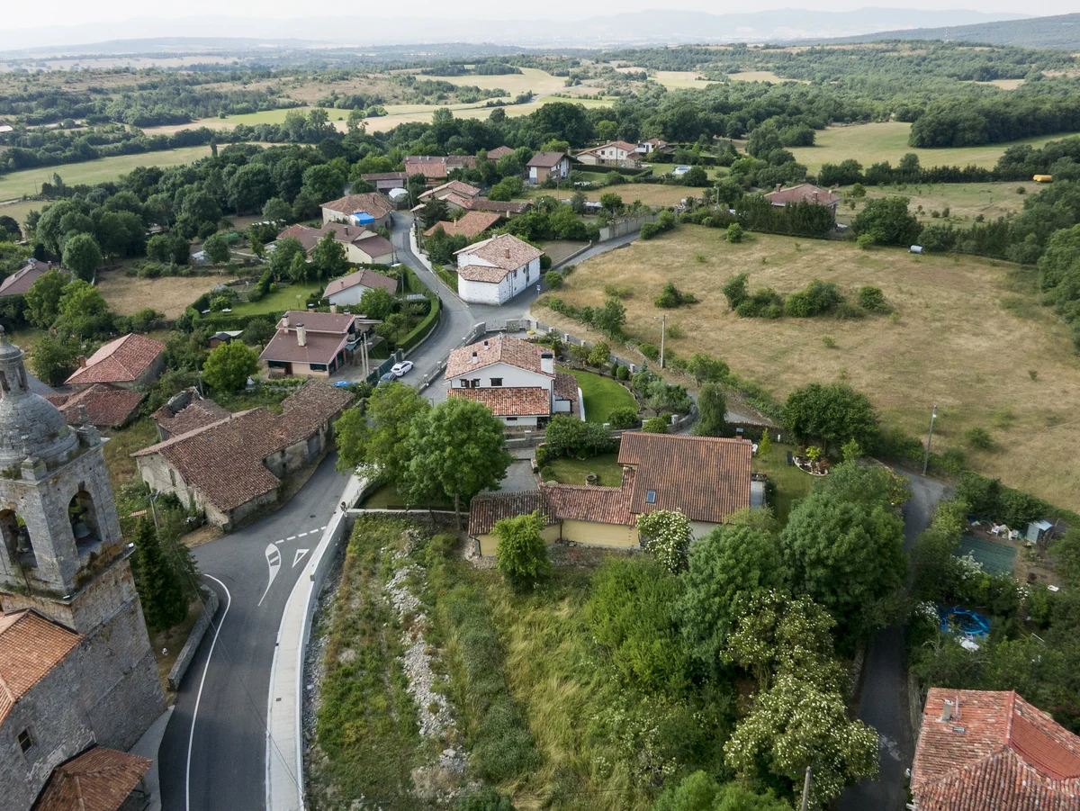 Vista aérea de un núcleo rural con viviendas, campos y caminos