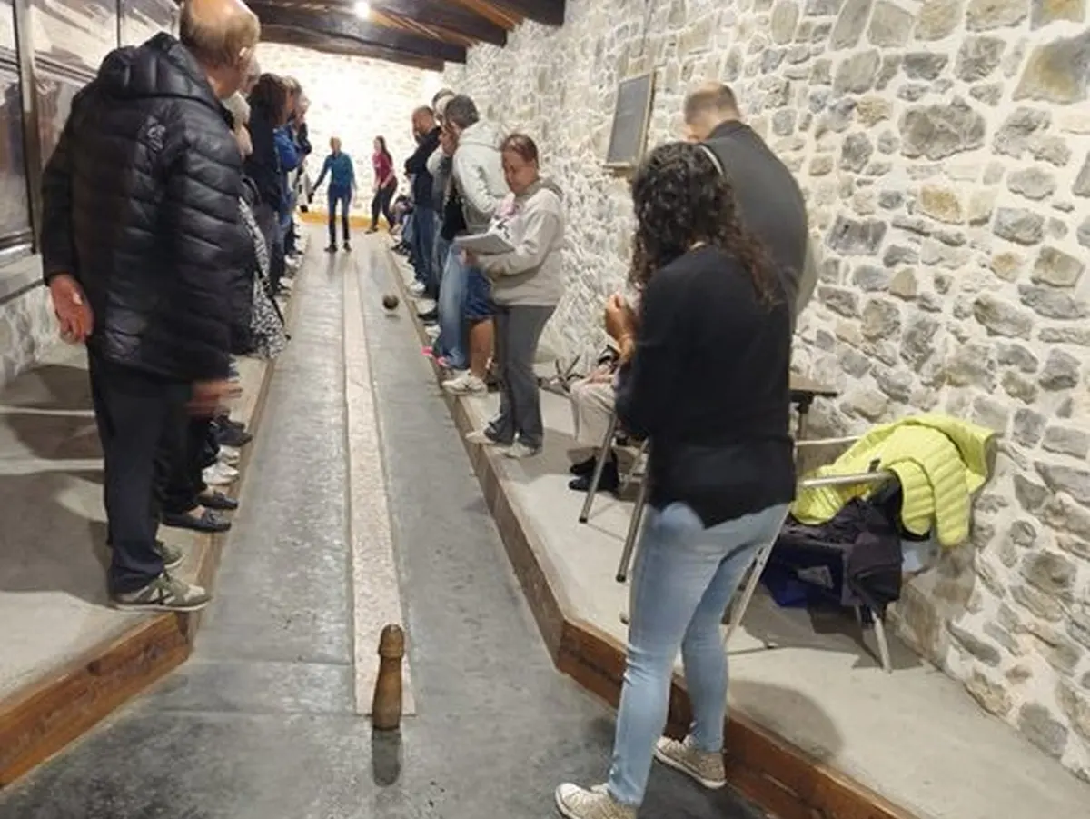 Jugadores y público en una bolera cubierta durante una competición de bolo alavés