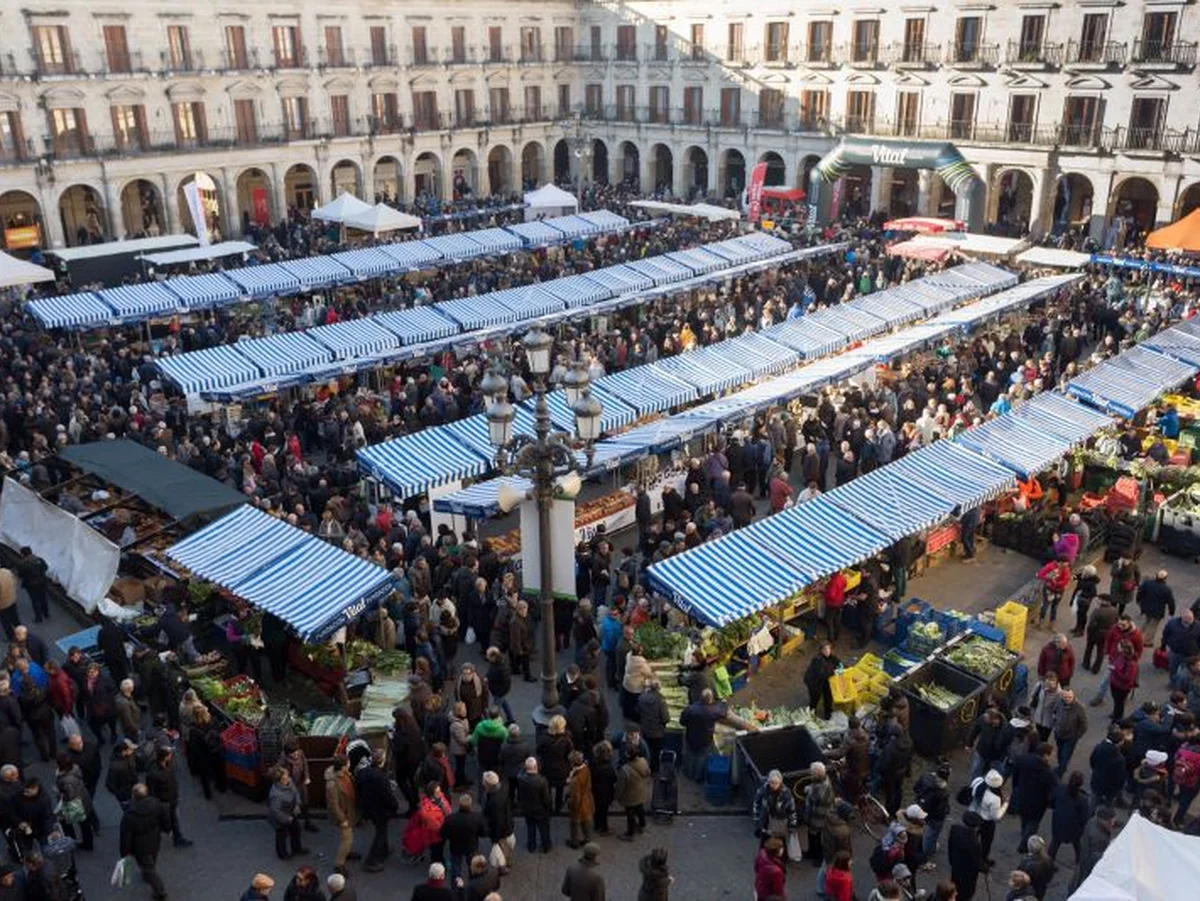 Vista general del Mercado de Navidad con puestos y visitantes en la Plaza de España de Vitoria-Gasteiz