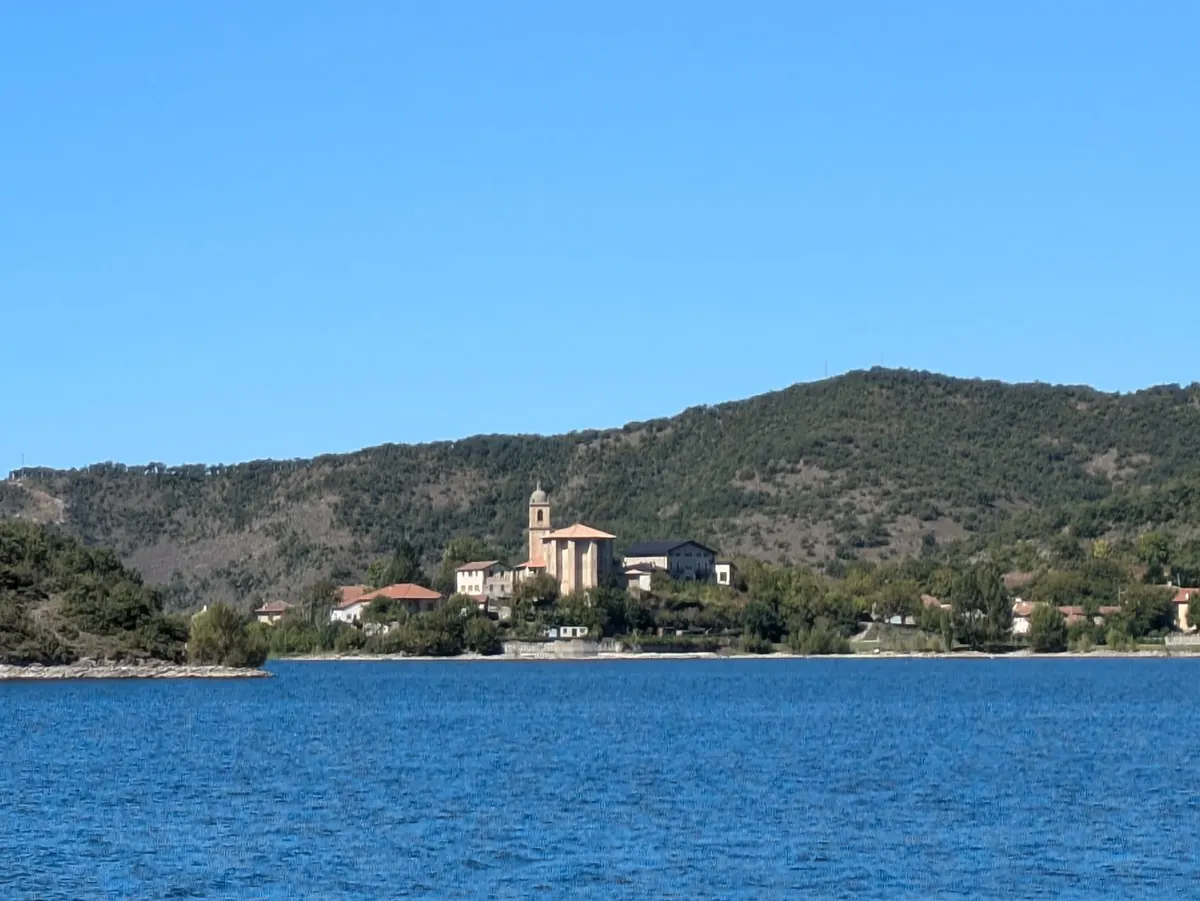 Vista de Ullibarri Gamboa junto al embalse, con la iglesia y el pueblo al fondo