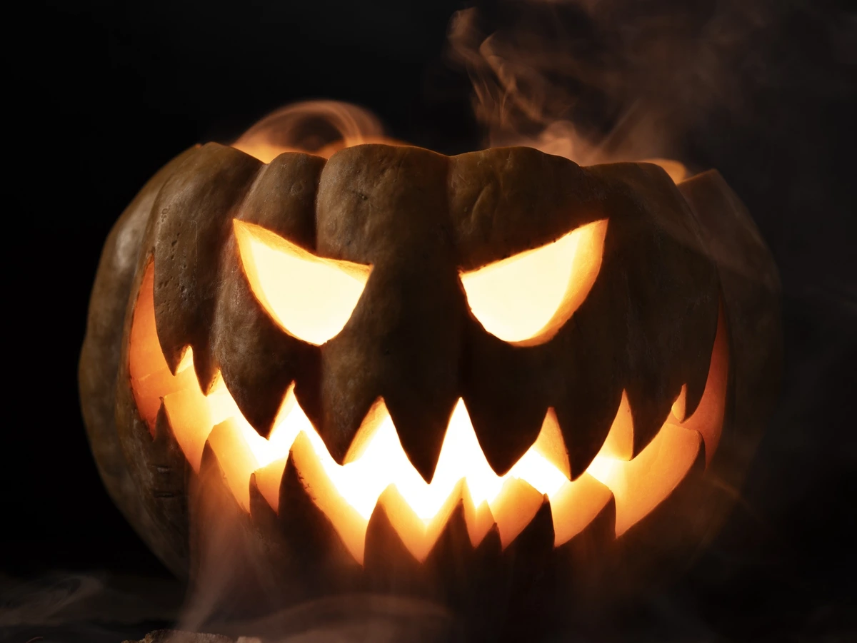 Calabaza de Halloween tallada e iluminada con ojos brillantes y sonrisa dentada